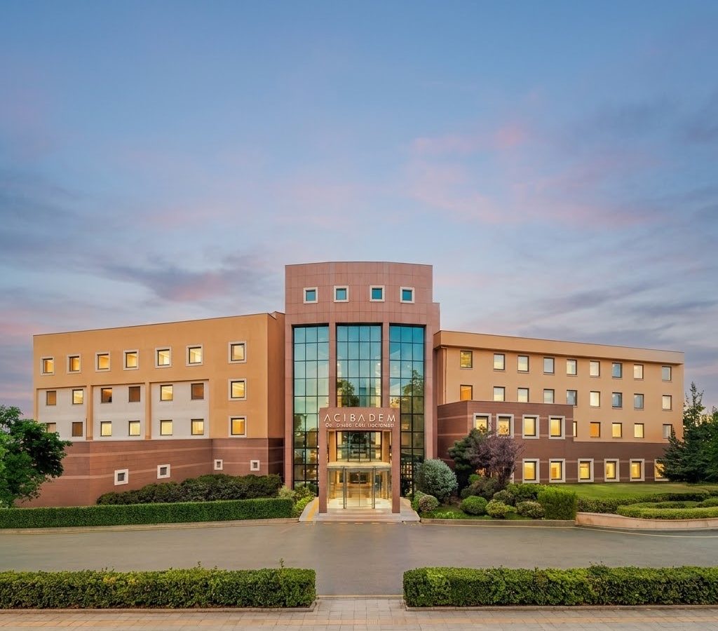 Modern hospital building with glass entrance and landscaped surroundings.